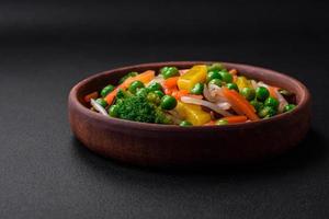 Delicious steamed vegetables broccoli, mushrooms, peas, carrots and onions photo