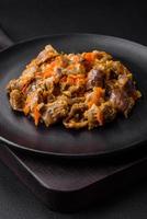 Delicious stewed chicken gizzards with carrots and tomato photo