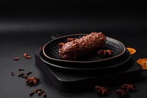 Delicious fresh eclair cake or profiterole with chocolate and nuts photo