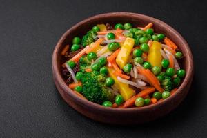 Delicious steamed vegetables broccoli, mushrooms, peas, carrots and onions photo