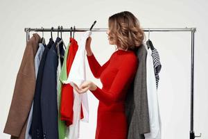 cheerful woman in a red jacket near the wardrobe light background photo