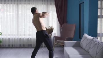 ambitiös och dynamisk boxare skugga boxning med hans tillbaka vände. de ung boxare praxis skugga boxning på Hem med ambition och takt. video