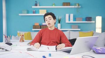 estresado masculino estudiante aburrido de mirando a libros. alto colegio masculino estudiante mirando a su libros a hogar y consiguiendo aburrido. video