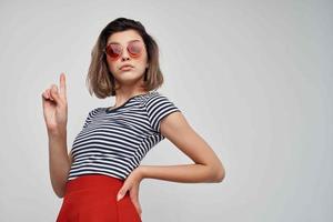 mujer vistiendo Gafas de sol rojo falda calle Moda aislado antecedentes foto