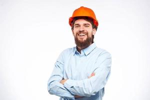 Cheerful man orange hard hat work industry professional lifestyle light background photo