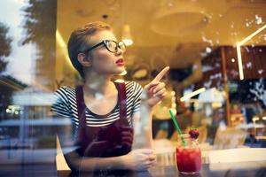 woman sitting in a restaurant with a cocktail loneliness pensive look photo