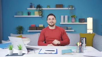 Young businessman showing how to exercise in his Home Office. He does arm exercises. Young freelance businessman in Home Office showing to camera how to do arm exercises step by step. video