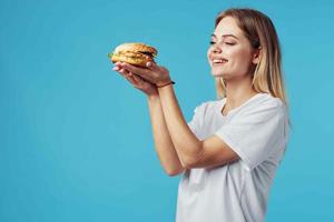 mujer con hamburguesa rápido comida entrega bocadillo divertido azul antecedentes foto