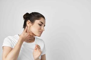 morena en un blanco camiseta dolor en el cuello salud problemas foto