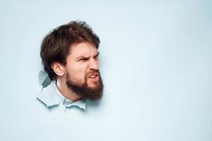 A disgruntled man head peeps out from behind the wall of an office career lifestyle photo