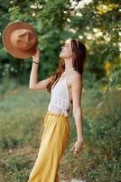 un joven hippie mujer bailando alegremente y sonriente formalmente en naturaleza en el caer. el concepto de económico consumo y cuidados personales foto