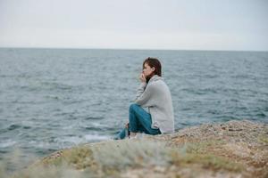 woman sweaters cloudy sea admiring nature Relaxation concept photo