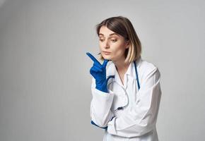 Doctor in blue medical gloves gesturing with his hands on a gray background cropped view photo