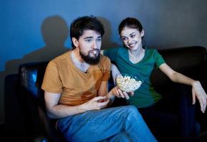 acecho televisión espectáculo en el noche en el sofá y hombre con mujer familia amigos foto