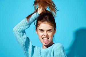 pretty woman in a blue sweater blue background Lifestyle photo