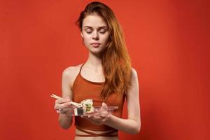 cute red-haired woman chopsticks rolls and seafood snack photo