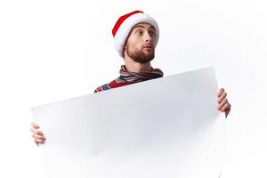 emotional man in a christmas hat with white mockup poster christmas isolated background photo