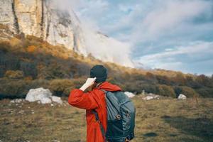 mujer con un mochila rojo suéter calentar sombrero paisaje otoño caído hojas modelo foto