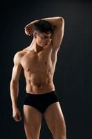 male bodybuilder with muscular body posing dark background photo