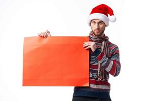 handsome man in New Year's clothes holding a banner holiday light background photo