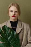 retrato de un mujer en Saco rojo labios Moda palma hoja estilo de vida posando foto