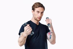 guy athlete in a black t-shirt with dumbbells in his hands on a white background photo