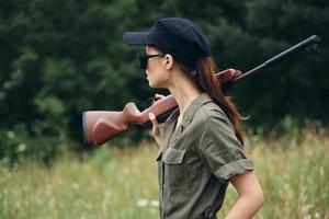 mujer en al aire libre escopeta en hombro lado ver caza estilo de vida armas foto