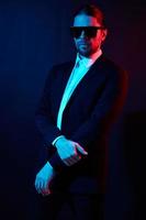 handsome man modern style suit fashion sunglasses neon light photo