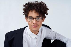 curly guy classic suit glasses cropped view light background portrait photo