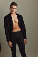 A man in a black shirt unbuttoned fashionable hairstyle Studio Model posing photo