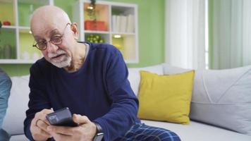 el abuelo, quien lo hace no saber cómo a utilizar el teléfono, pregunta su nieto cómo a utilizar el teléfono. video