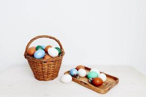 Easter holiday in colored eggs in a basket and on a wooden board photo