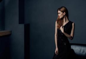 Portrait of elegant lady in black dress in gray room cropped view photo