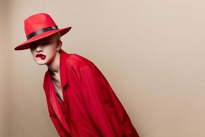 retrato de un mujer rojo chaqueta y sombrero rojo labios Moda beige antecedentes foto