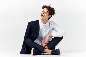 stylish young man with curly hair and in a classic suit on a light background photo