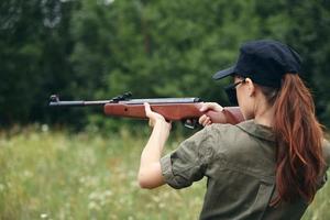 Woman Holds aiming hunting green overalls photo