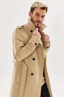 a man in a coat holding a collar autumn style fashion photo