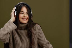 bonito mujer en un suéter escuchando a música con auriculares divertido estudio modelo foto
