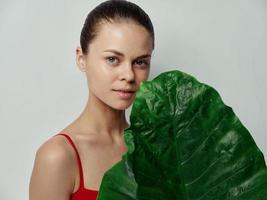 dermatology beautiful woman with palm leaf and red t-shirt photo