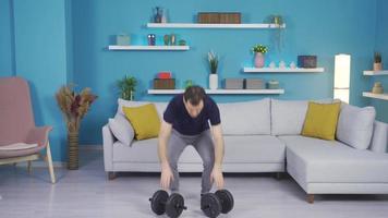 Weak, inexperienced man working out with equipment at home. Inexperienced powerless man trying to make body at home with the help of equipment. video