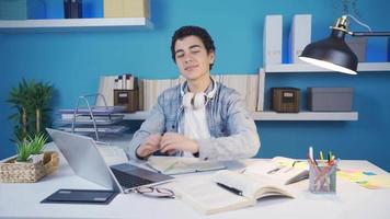 Happy male student is making hearts with his hands, smiling towards the camera. video