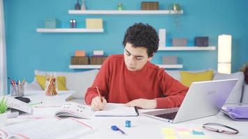 knap en geslaagd mannetje leerling aan het studeren Bij huis, huiswerk. mannetje leerling aan het studeren zijn huiswerk en lessen Bij huis. attent mannetje leerling gefocust Aan huiswerk. video