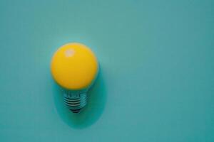 flat lay photo of yellow bulb on turquoise blue background. Illustration