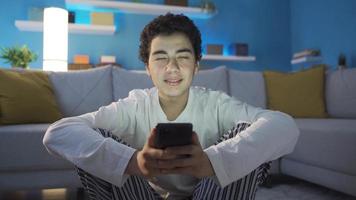 Boy using smartphone in fun and cheerful mood. video