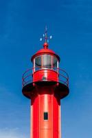 Red lighthouse against clear blue sky, close-up photo