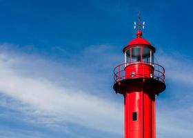 Red lighthouse against clear blue sky, close-up photo