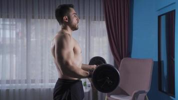 Young athlete man is trying to have a more muscular and shapely physique. Bodybuilder man who works hard to develop his arm muscles and get stronger. video