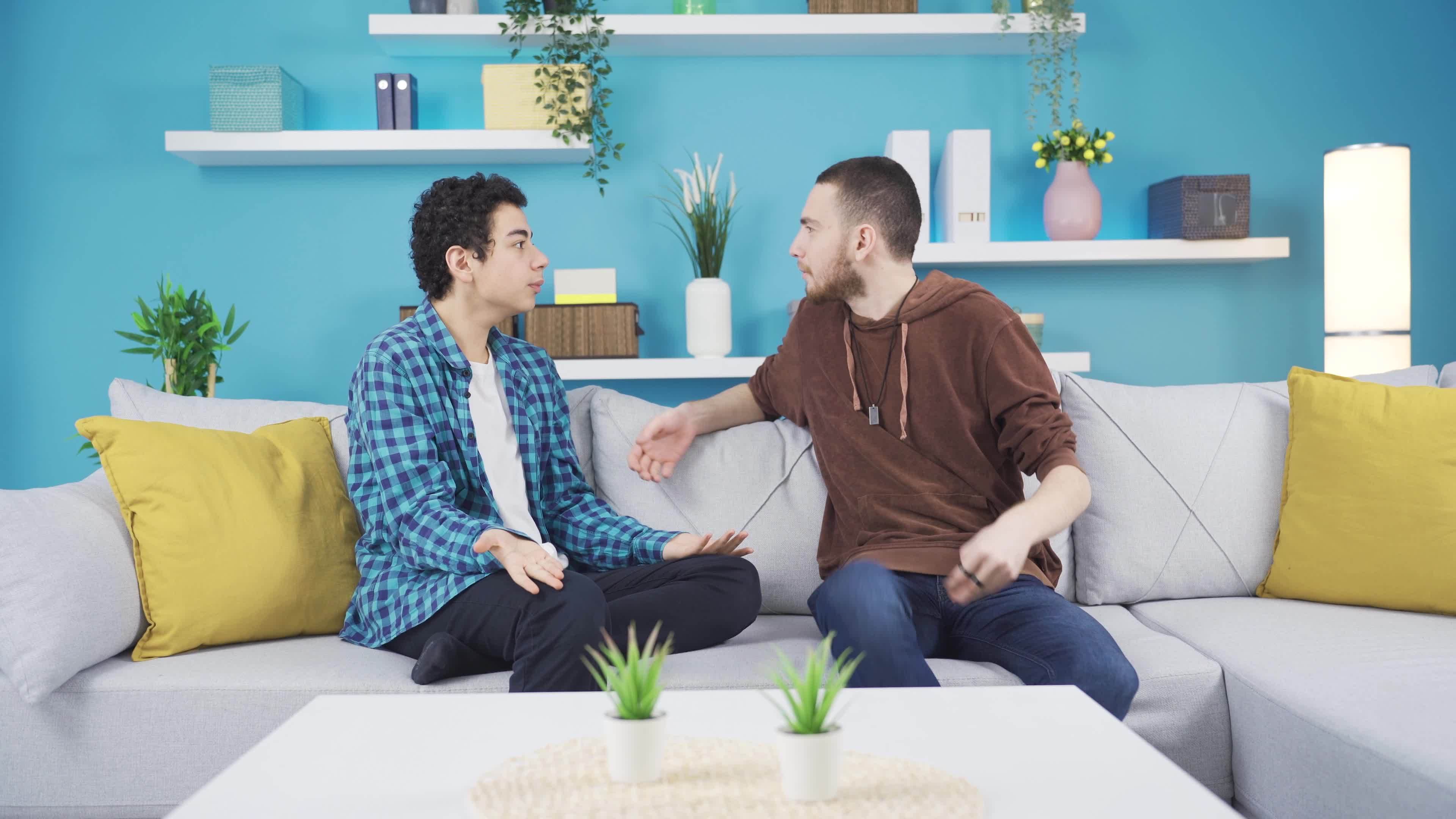 Young man arguing with his younger brother at home, Sibling quarrel