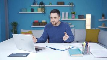 The man working in the home office gets angry with what he sees on the laptop and fails. video