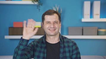 Portrait of positive man greeting, waving, saying goodbye while looking at camera. Happy and sympathetic man waving, saying bye bye, greeting, friendly approaching. video